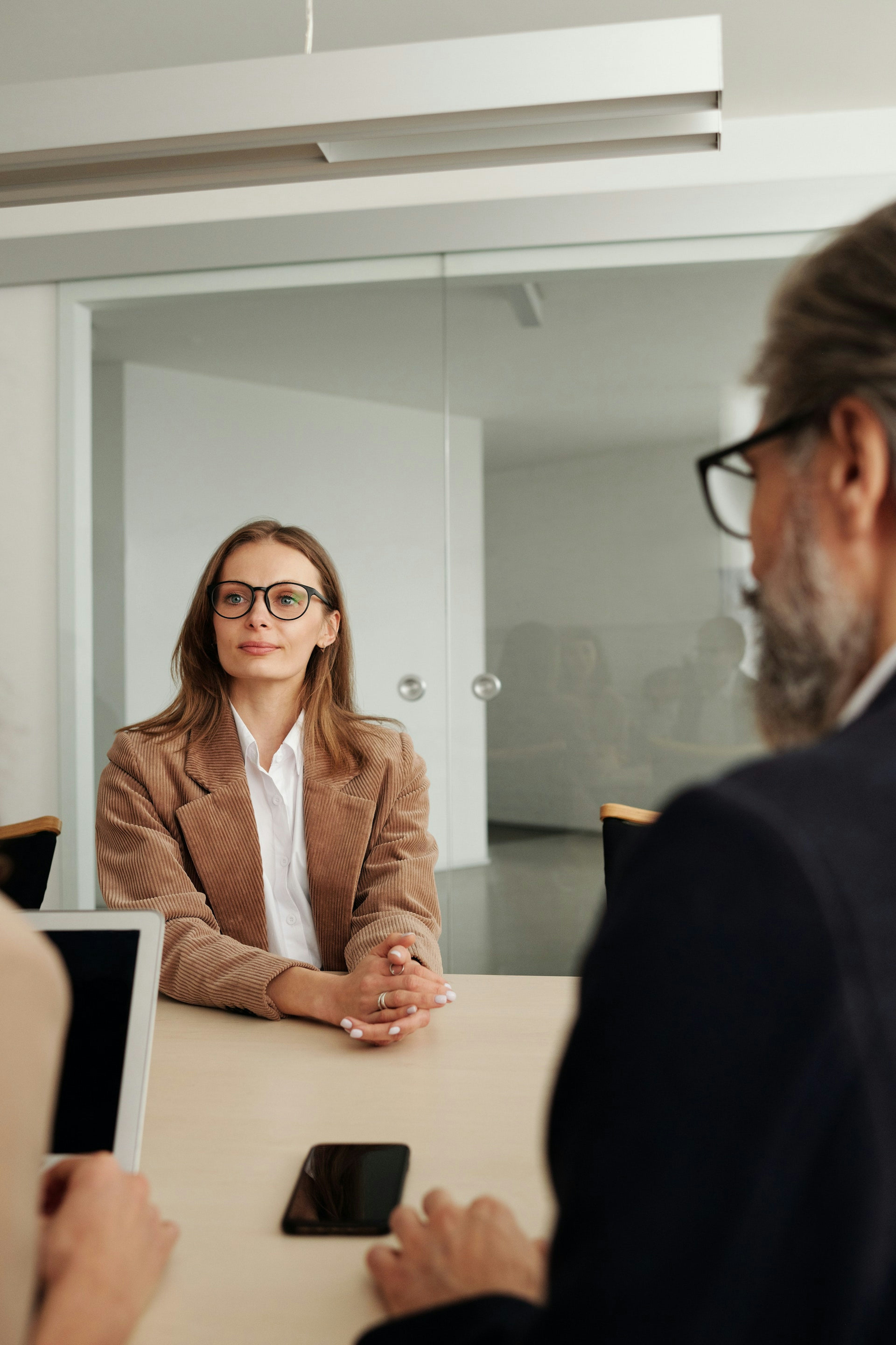 Woman being interviewed by 2 people who are offscreen