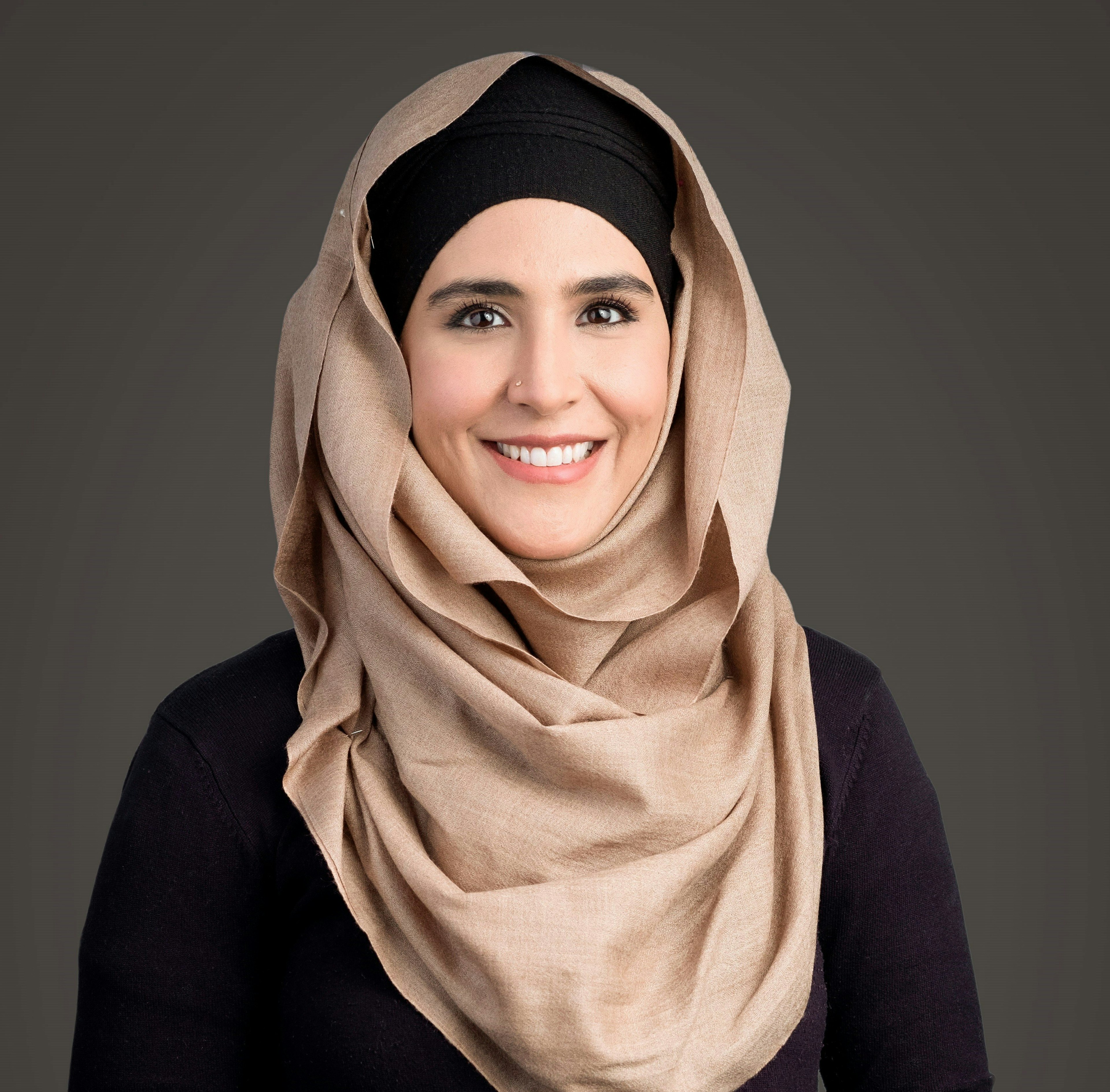 Woman in black outfit wearing tan hijab