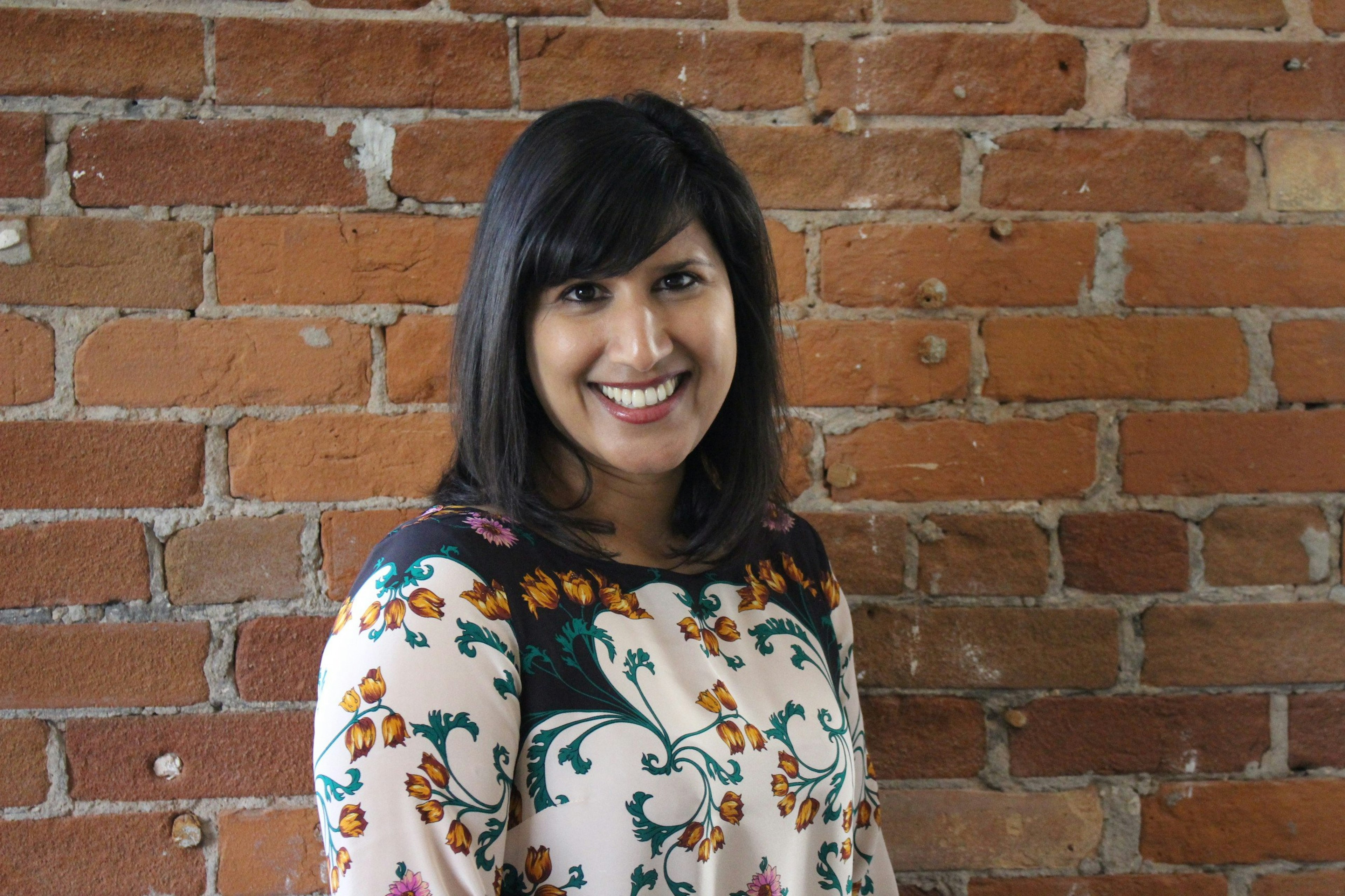 Woman in front of brick wall