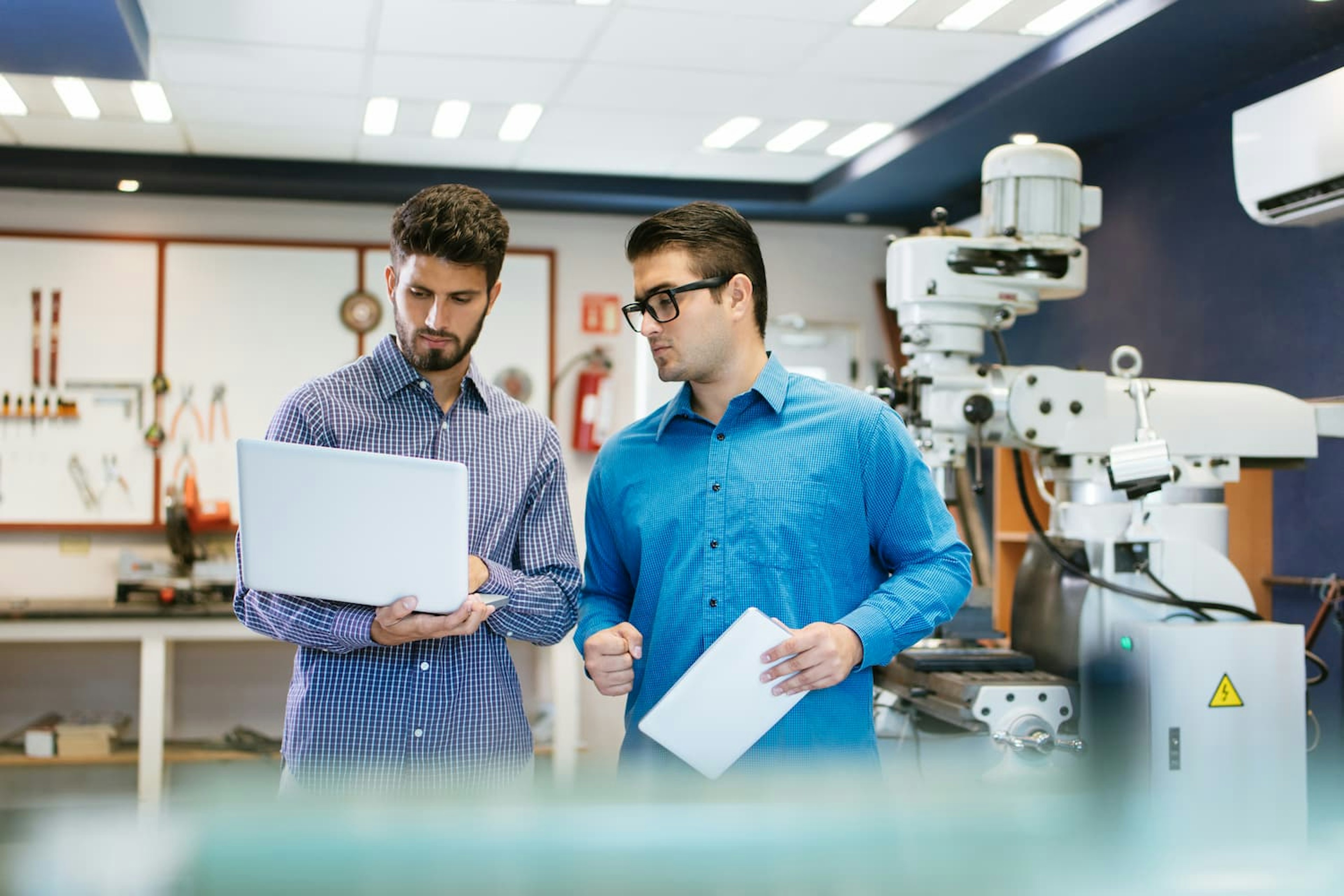 Two man looking at laptop in technical environment