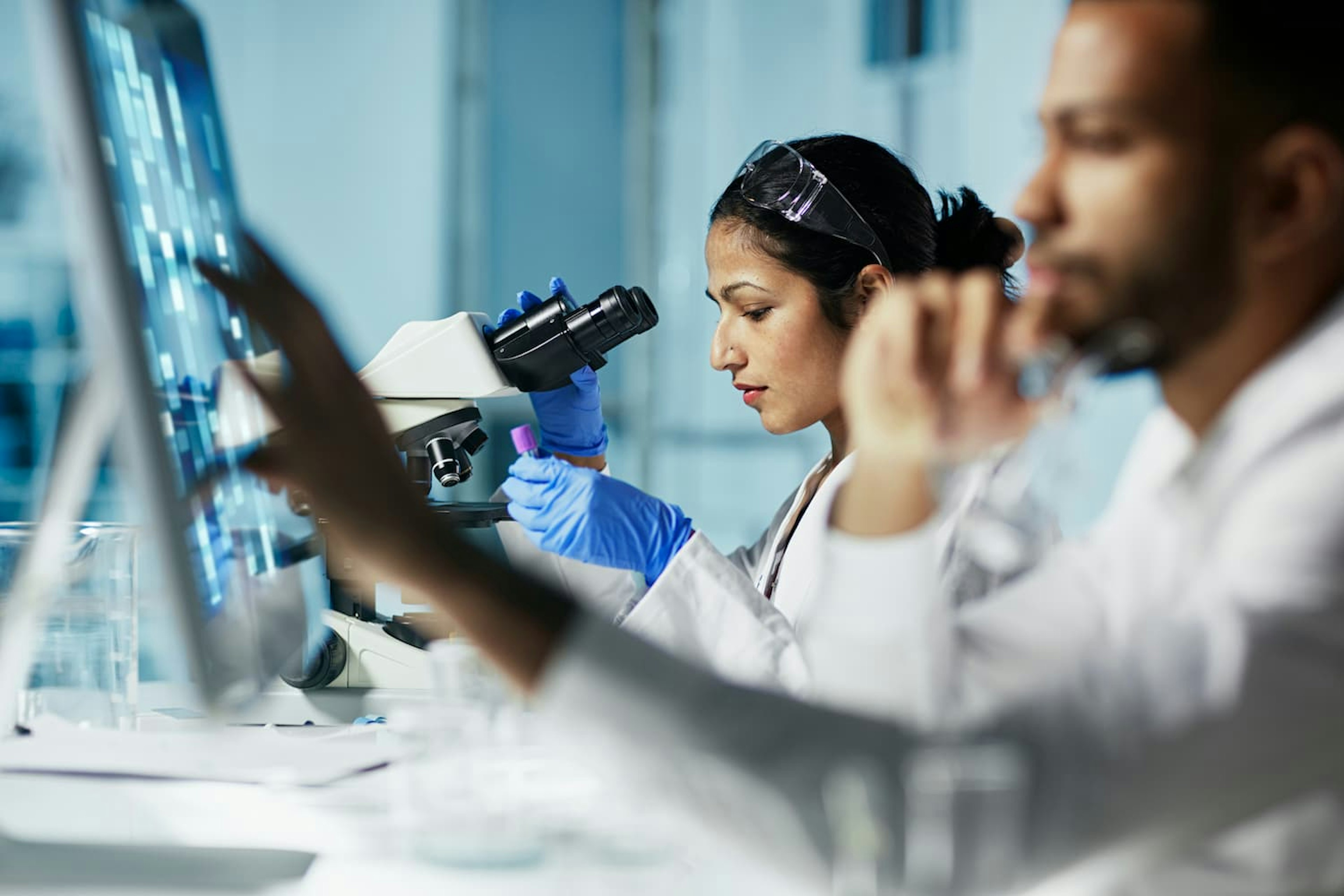 Female lab technician using microscope