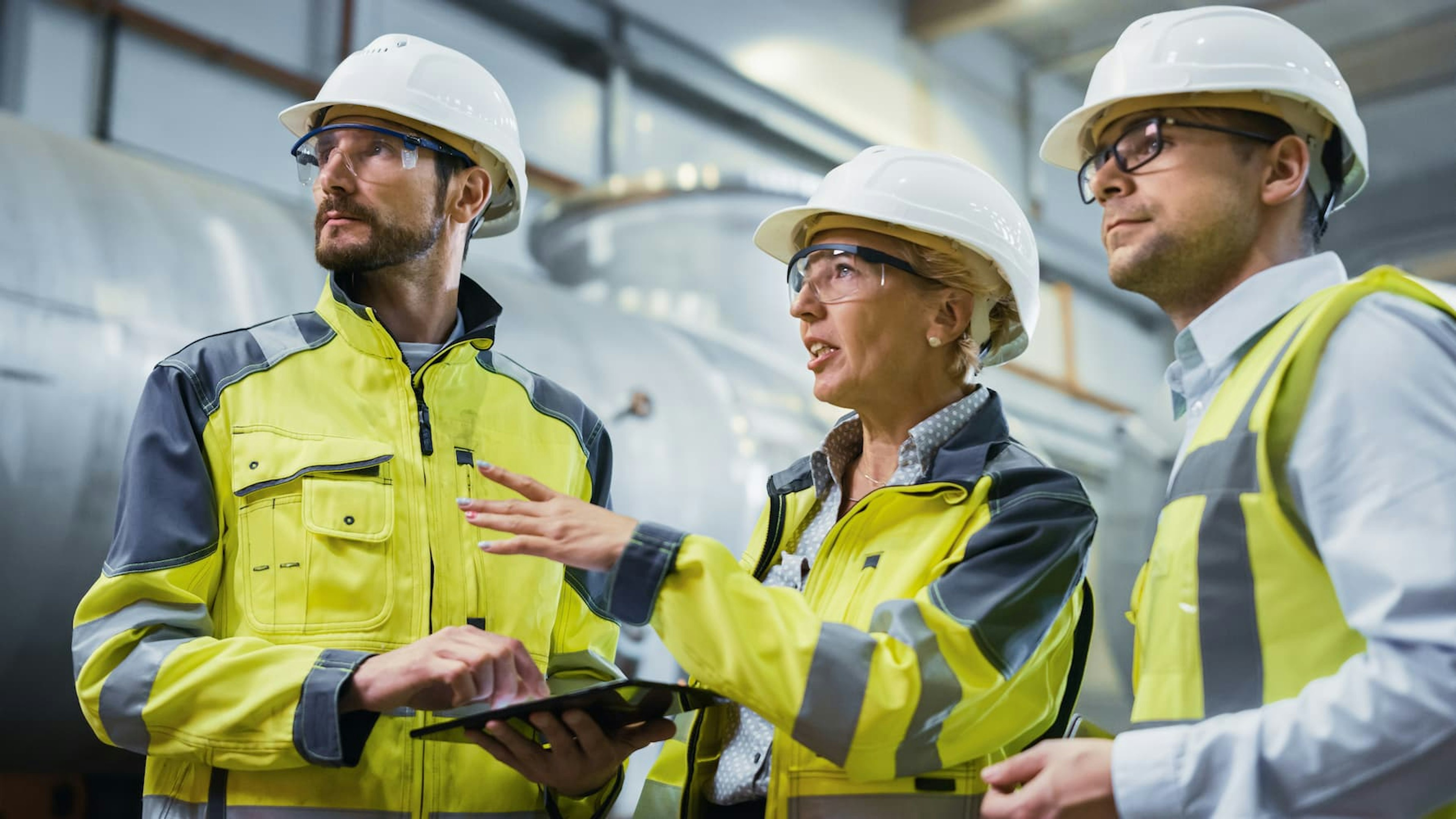 Three engineers with safety clotihng and helmets